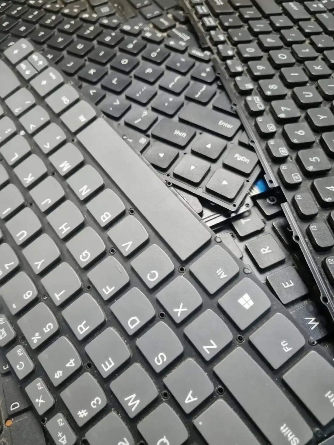 Tumpukan keyboard laptop di meja servis