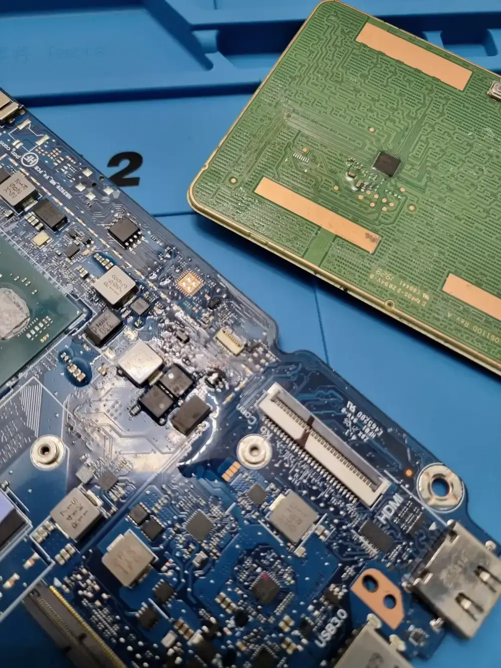 Motherboard laptop yang sedang diperbaiki